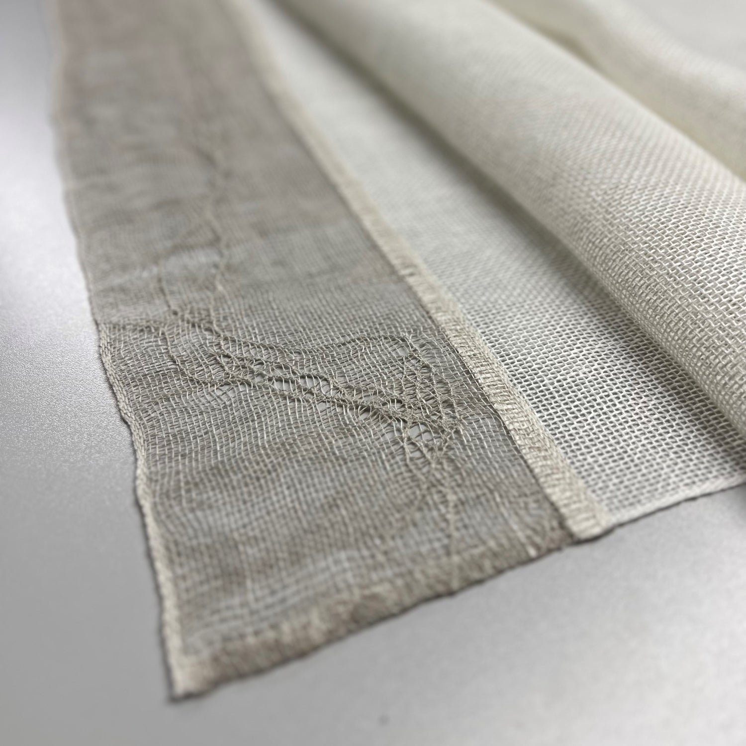 Handwoven linen table runner in white with decorative ends in natural color 50x140 cm